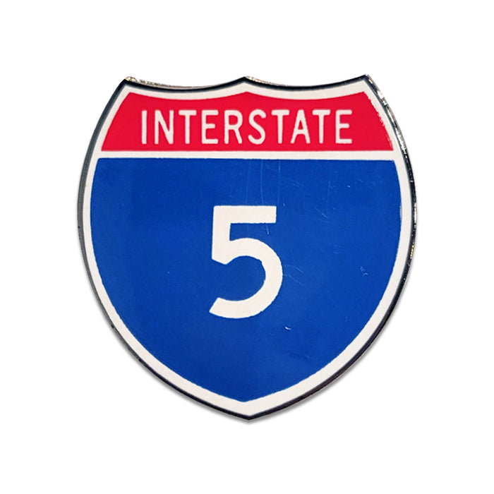 Shiny enamel pin shaped like an interstate highway shield with 'INTERSTATE 5' on a white background.