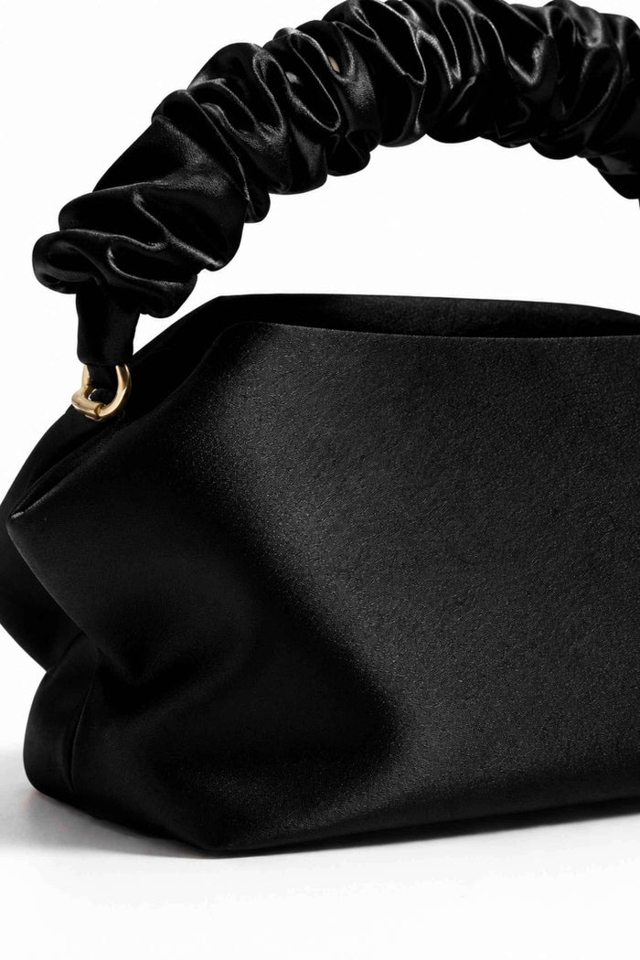 Close-up of black satin clutch with a gathered, ruched handle made of shiny black fabric, detailed with gold hardware, SKU: CB61275