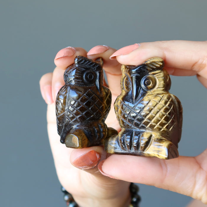 hands holding 2 Tigers Eye Owls