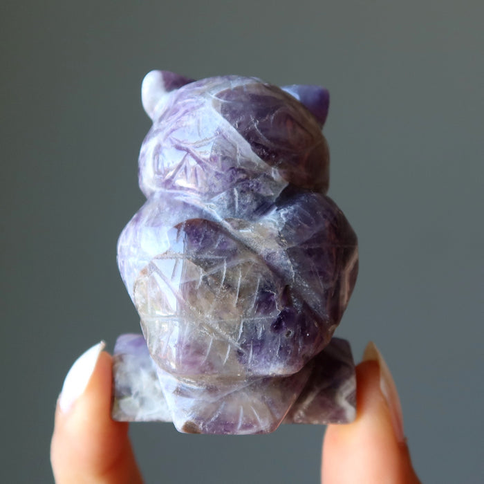 fingers holding showing the back of 2.25-2.5 Inch purple Amethyst owl