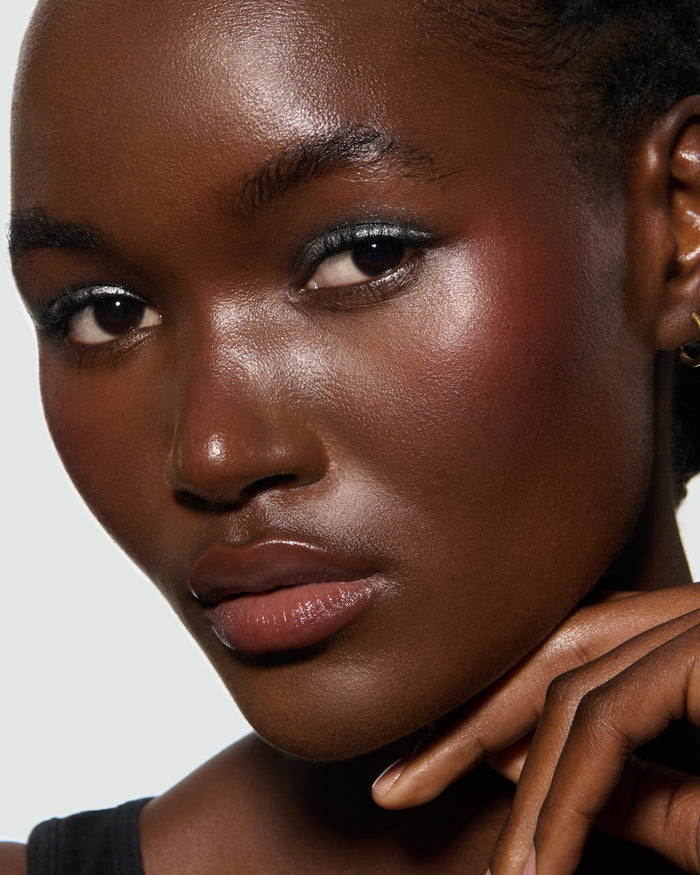 Close-up of a model's face, against a neutral background, wearing Aria Liquid Lurex Liquid Eyeshadow, a true, cool, clear silver.