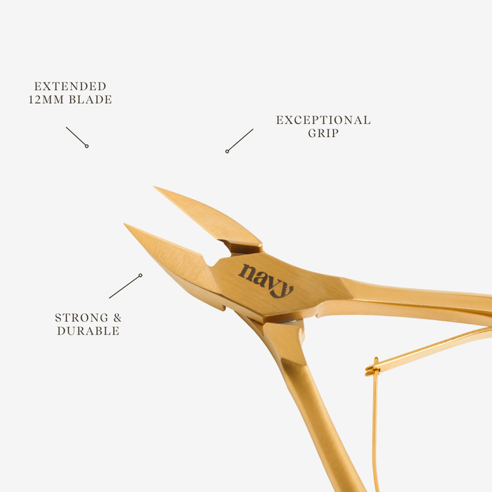 Gold-colored nail clippers with 'navy' branding on a white background