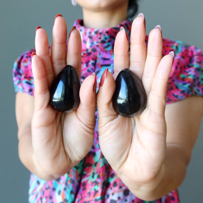 hand holding black agate eggs