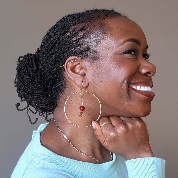 female wearing carnelian hoop earrings