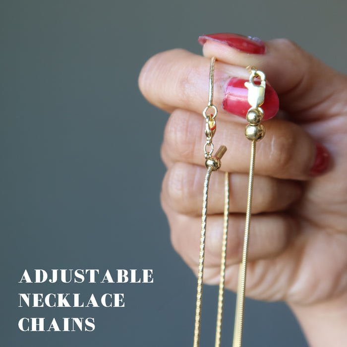 hand holding two gold chains showing lobster claw clasps