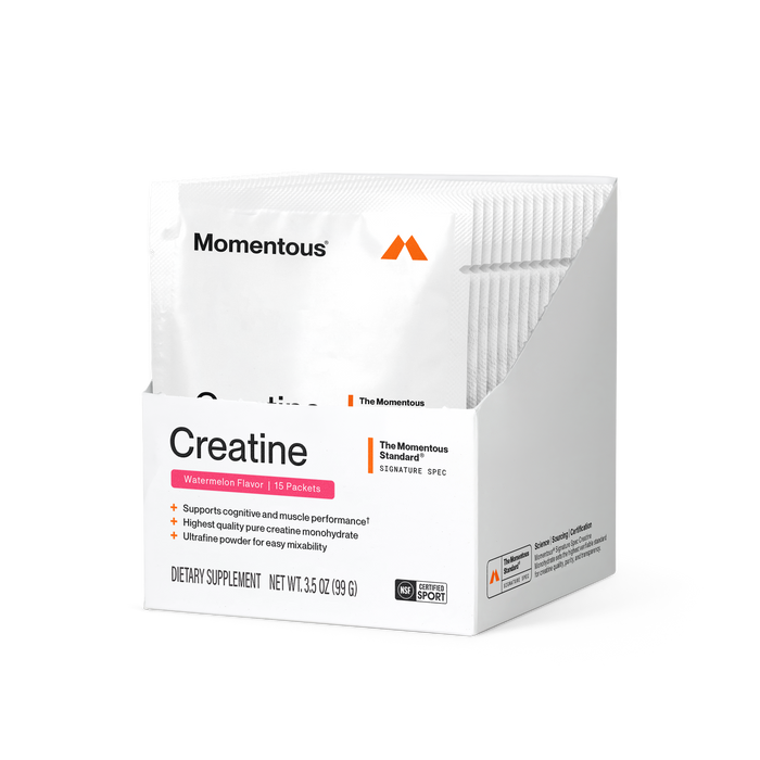 Momentous Creatine dietary supplement carton, Watermelon Flavor, 15 packets. Shows a white foil packet with Momentous logo behind the box. Front panel reads "Creatine," "Watermelon Flavor | 15 Packets," "The Momentous Standard – Signature Spec," with claims "Supports cognitive and muscle performance," "Highest quality pure creatine monohydrate," "Ultrafine powder for easy mixability." Includes NSF Certified Sport badge and Net Wt. 3.5 oz (99 g).