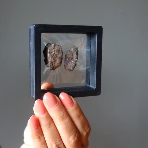 holding two meteotire in Black Floating Display Case