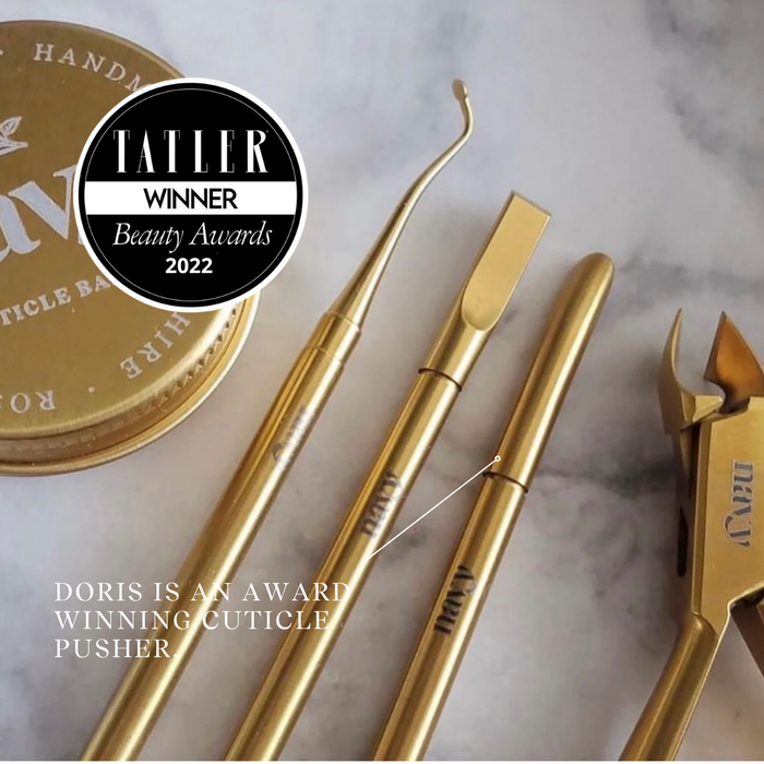 Gold cuticle pusher set with 'Tatler Winner Beauty Awards 2022' badge on a marble background