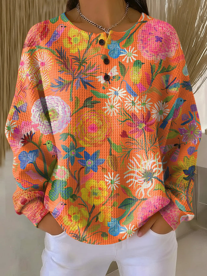 Freja women's waffle-knit sweater in orange with a colorful floral print