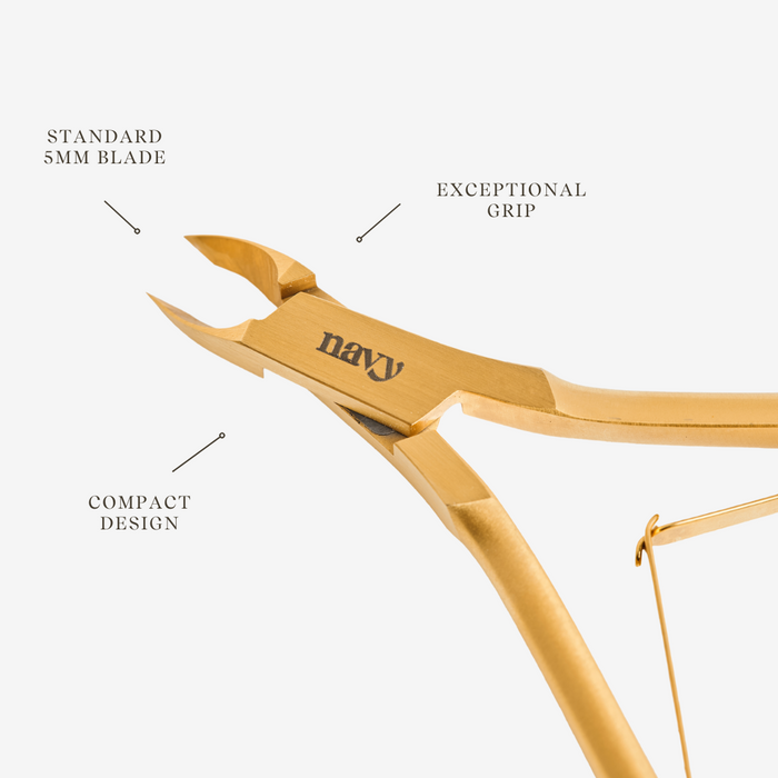 Gold-colored nail clippers with 'navy' branding on a white background