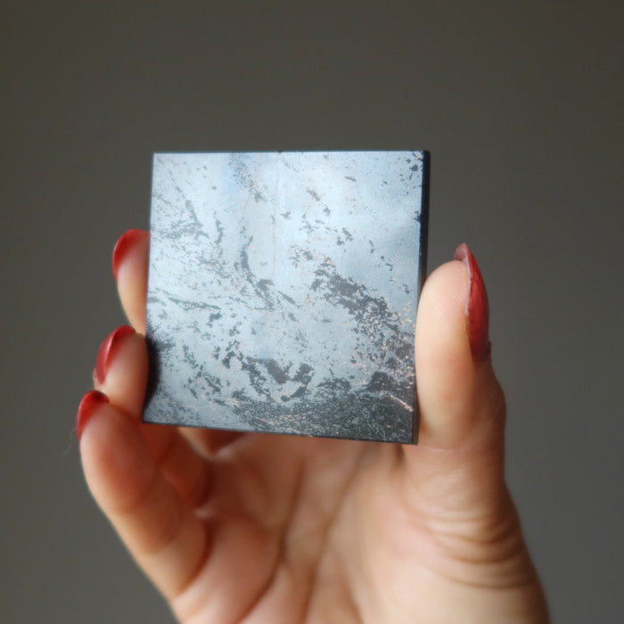 hand holding hematite pyramid showing bottom
