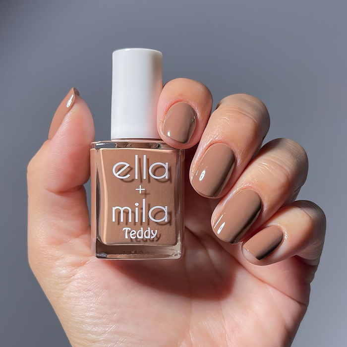 Honey Bear cool brown nail polish manicure on a light skin tone, holding the bottle