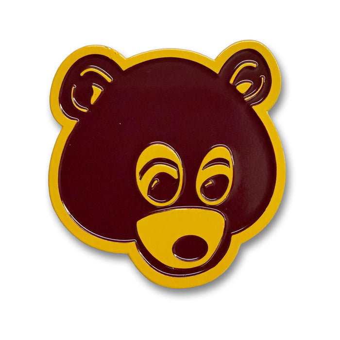 kanye bear pin in a burgundy color with a golden yellow outline.