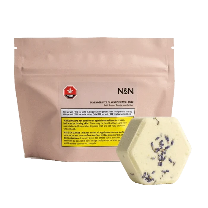 Lavender Fizz Body Scrub in a white container with a label, angled slightly against a dark backdrop.