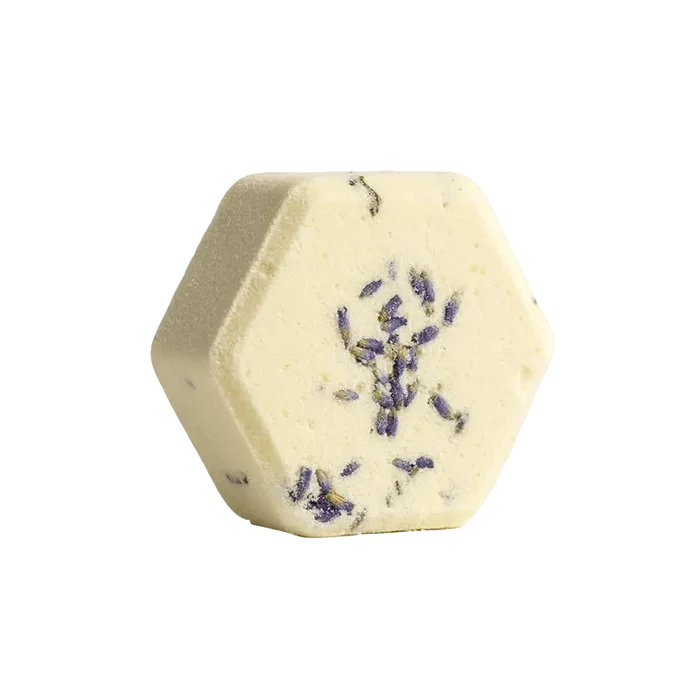 Lavender Fizz Body Scrub presented in a close-up, overhead shot highlighting its granular texture and pale purple hue.