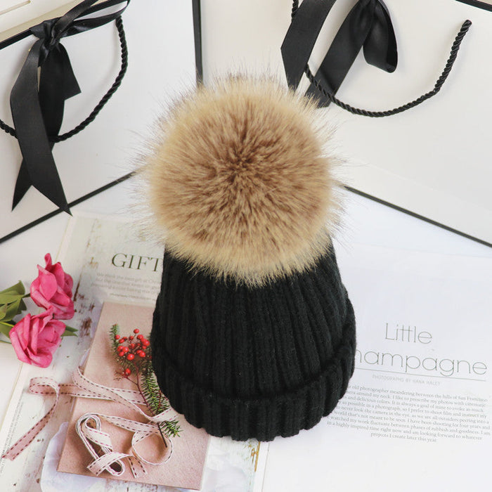 Classic cozy knit beanie with a plush pom accent shown in multiple colors