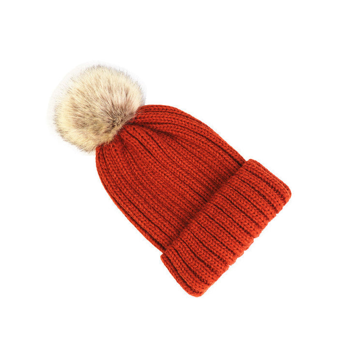 Classic cozy knit beanie with a plush pom accent shown in multiple colors