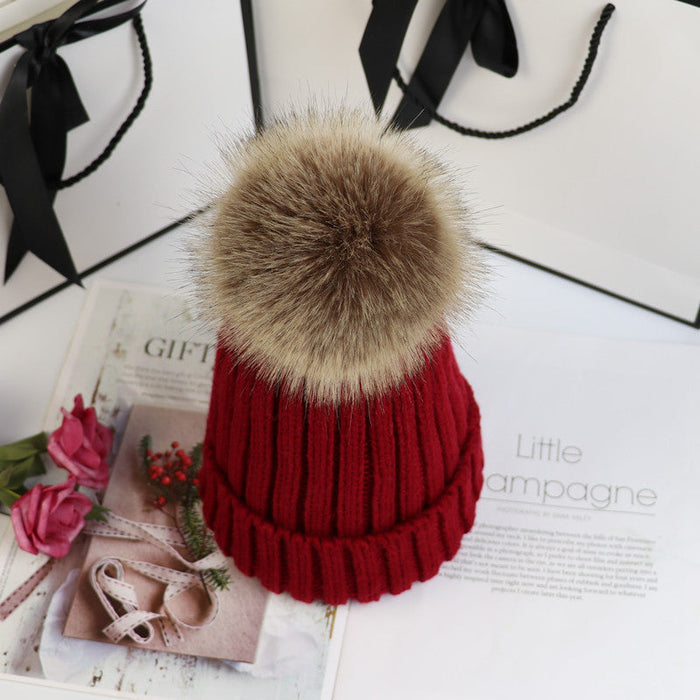 Classic cozy knit beanie with a plush pom accent shown in multiple colors