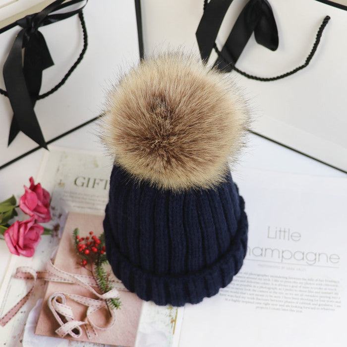 Classic cozy knit beanie with a plush pom accent shown in multiple colors
