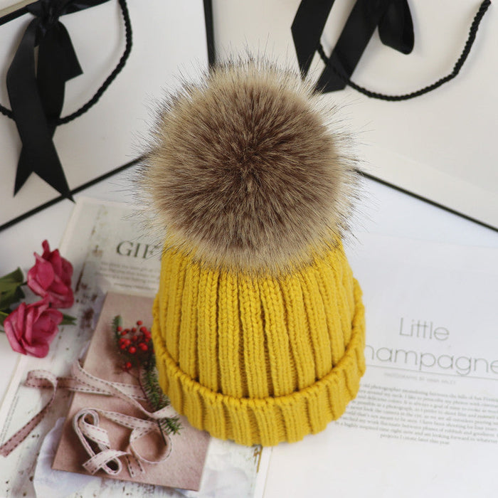 Classic cozy knit beanie with a plush pom accent shown in multiple colors