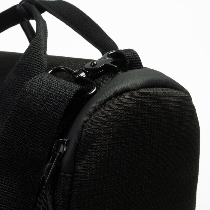 Close-up of a black textured CPAP insert with a black zipper, black webbing strap, and black metal clip hardware against a white background.