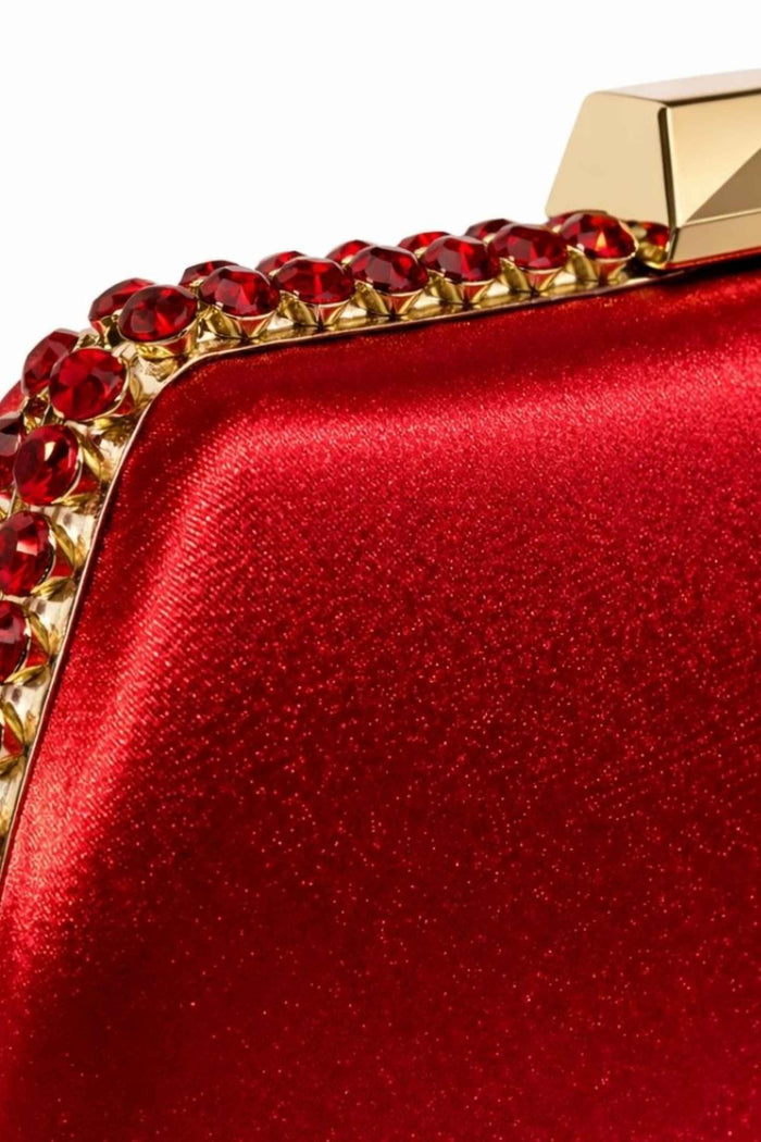 Side angle of the red satin clutch showing the gold clasp and gemstone border, emphasizing its sophisticated and glamorous style for evening wear.