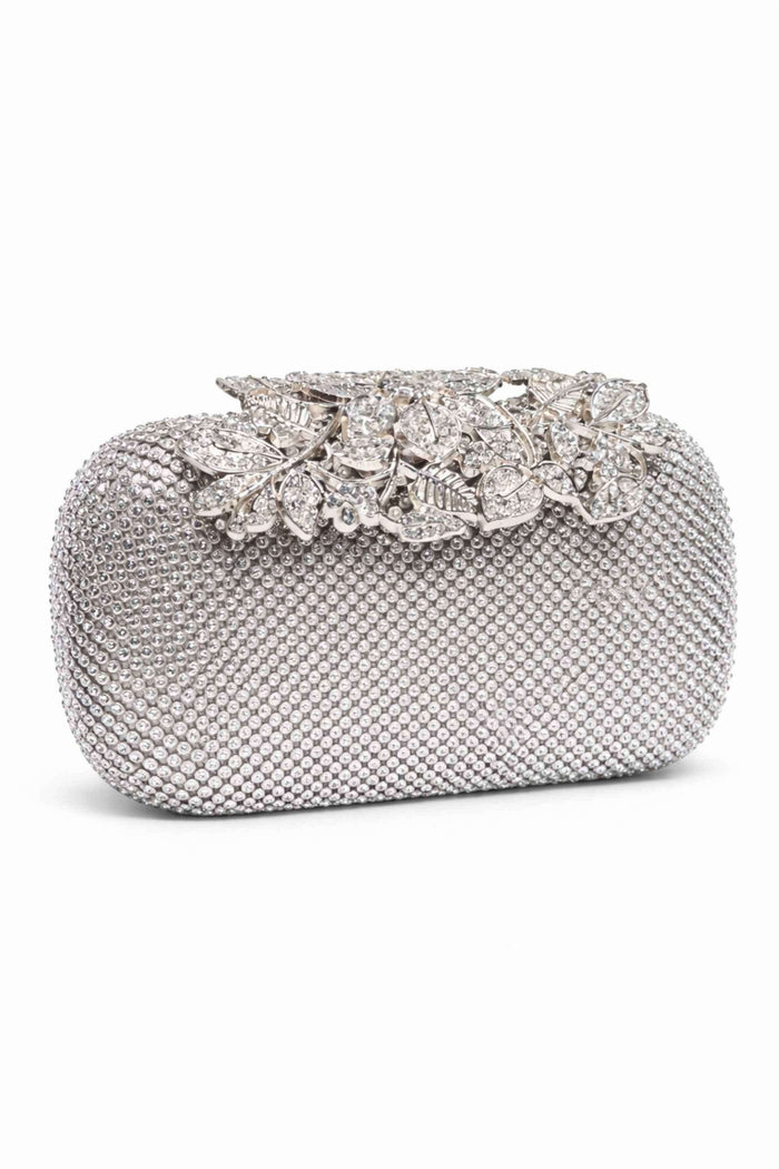 Silver clutch bag covered in small beads with a decorative silver-tone floral and leaf clip adorned with sparkling rhinestones, perfect for evening events.
