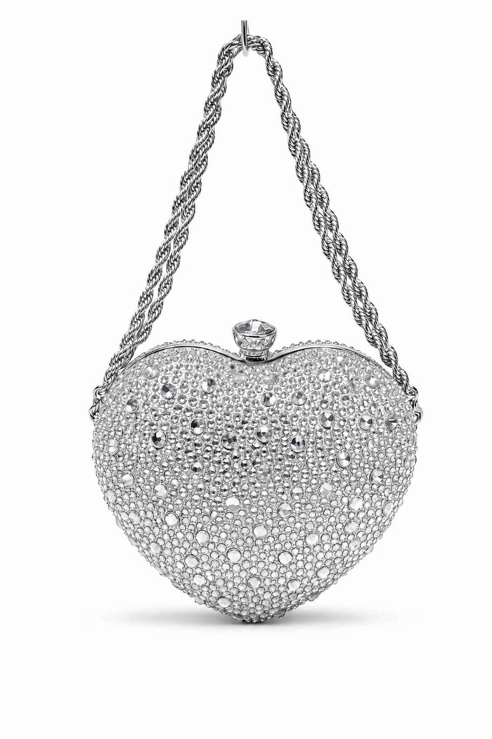 Silver clutch bag covered in sparkling rhinestones with a large clear gemstone clasp and a twisted silver chain handle, elegant evening accessory