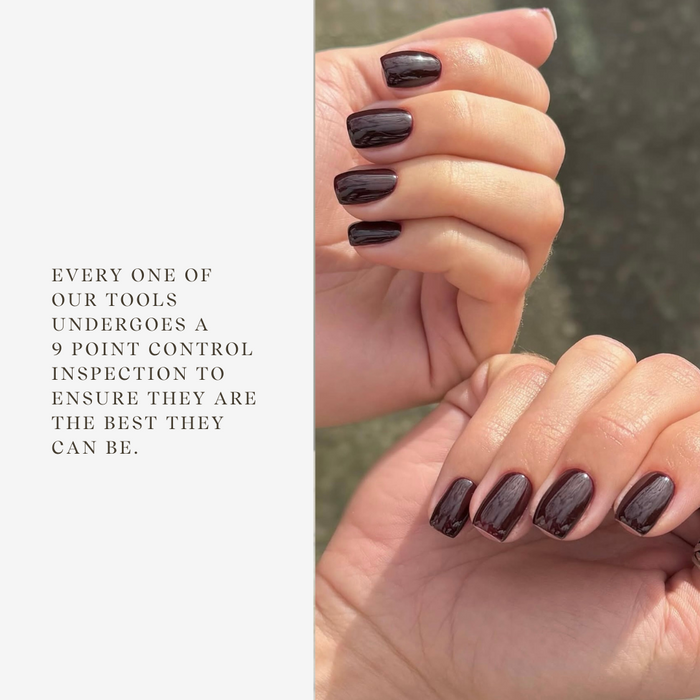 Close-up of hands with dark nail polish against a neutral background