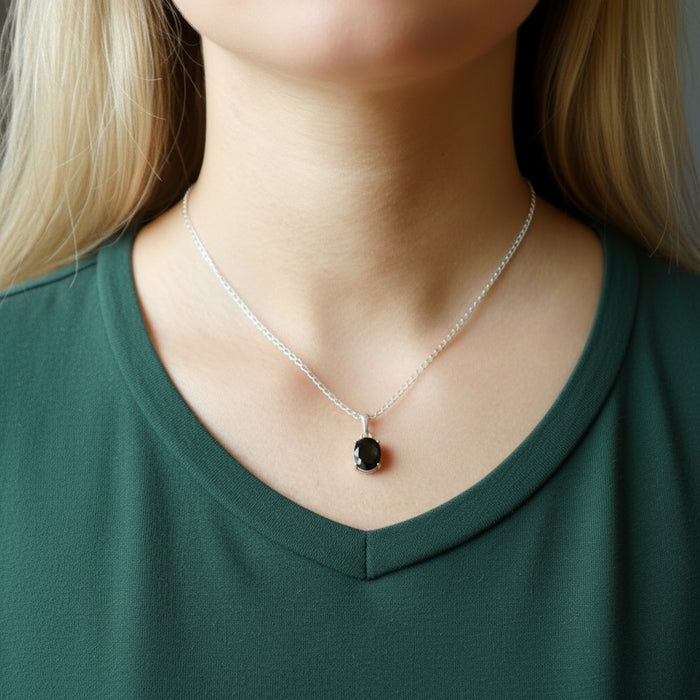 woman modeling faceted moldavite necklace