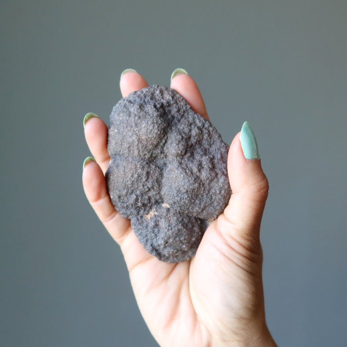hand holding brown moqui marble cluster