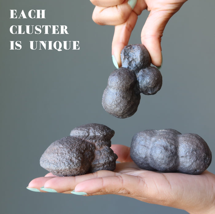 hand holding three brown moqui marble clusters