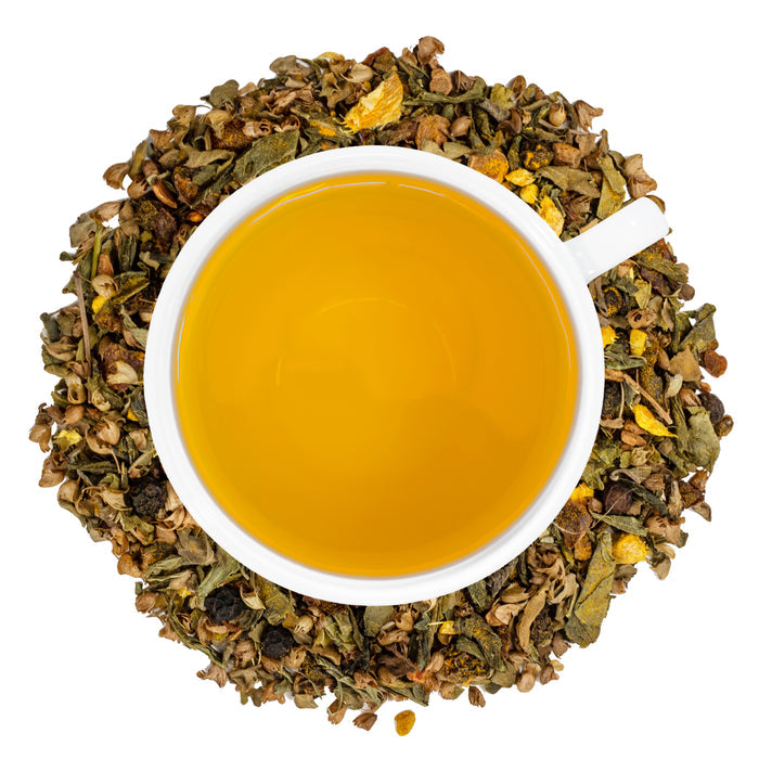 A white cup of Organic Decaf Anti-Inflammatory Tea surrounded by the loose leaf blend.
