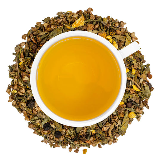 A white cup of Organic Decaf Anti-Inflammatory Tea surrounded by the loose leaf blend.