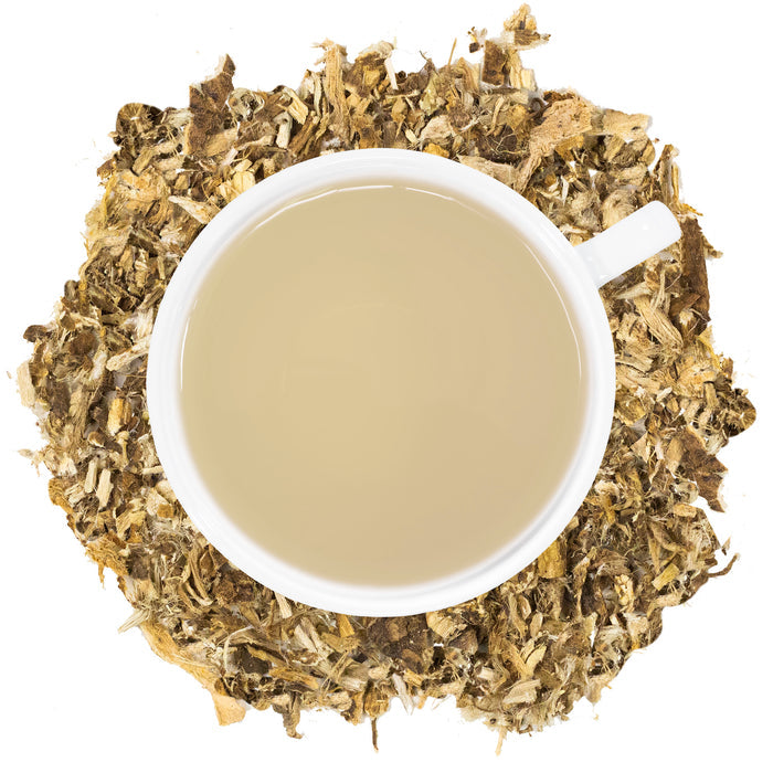 Marshmallow Root Tea in a white mug with Marshmallow root spread around it.