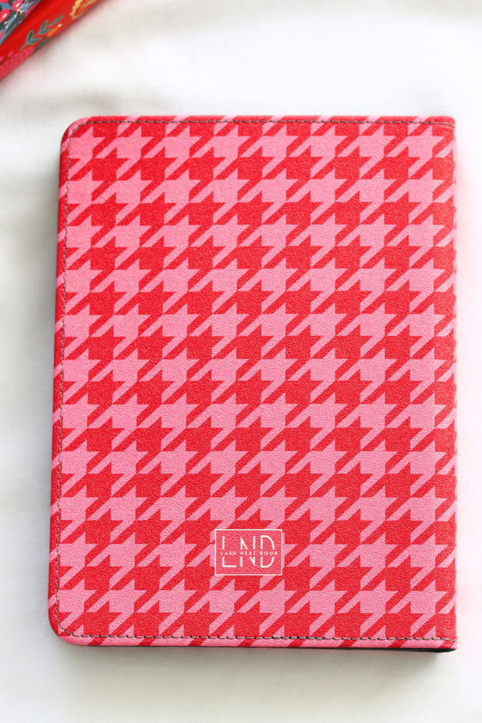 Pink and white houndstooth patterned kindle with 'LND' branding on a white background