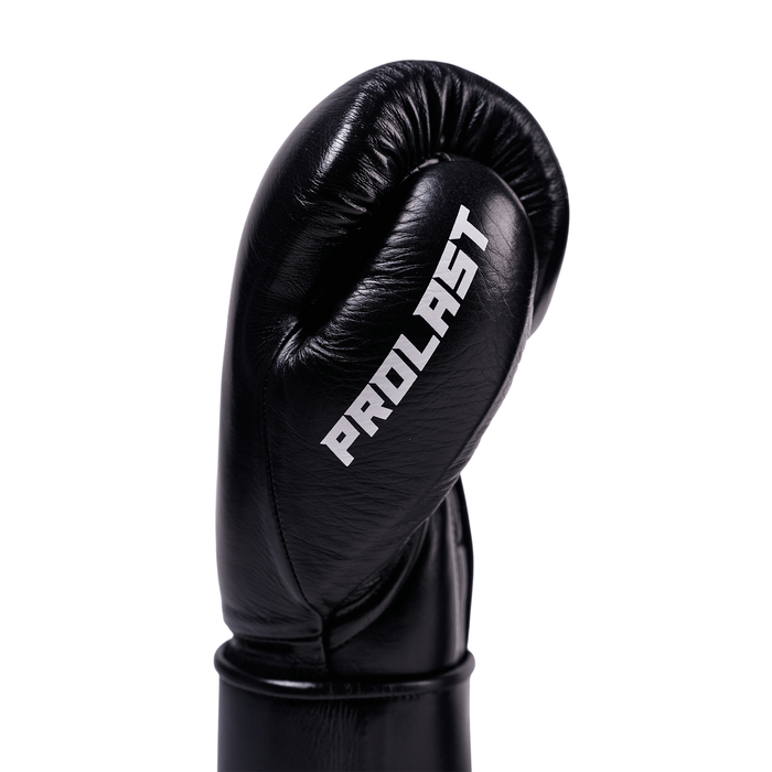 PROLAST PG professional boxing gloves in charcoal black, close-up of one glove's thumb side with PROLAST lettering