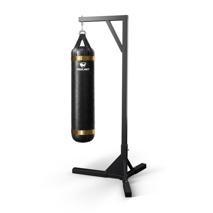 PROLAST 5 ft 100 lb stock heavy bag, black with gold trims, hanging from a PROLAST single bag stand on a steel snap hook through its D-rings (stand sold separately)