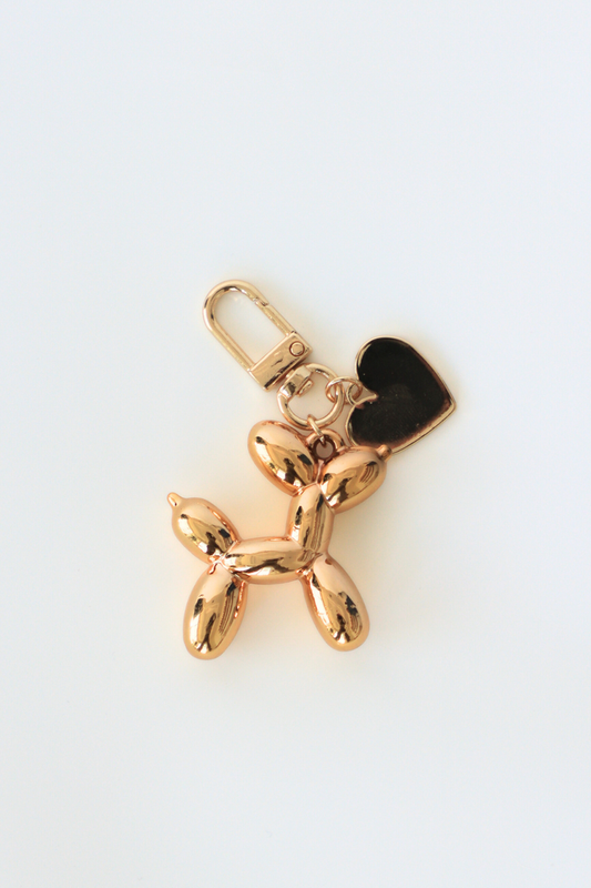 Gold balloon dog keychain on a white background