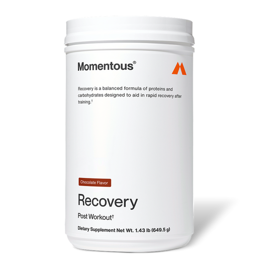 White Momentous Recovery container labeled “Chocolate Flavor.” Text reads: “Momentous. Recovery is a balanced formula of proteins and carbohydrates designed to aid in rapid recovery after training. Recovery. Post Workout†. Dietary Supplement Net Wt. 1.43 lb (649.5 g).”