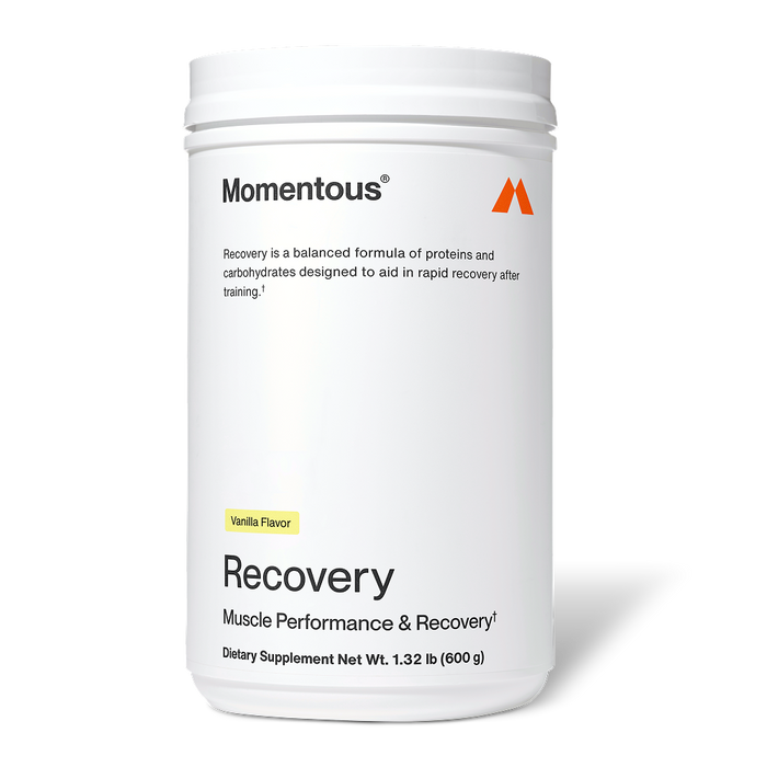 White Momentous Recovery container labeled “Vanilla Flavor.” Text reads: “Momentous. Recovery is a balanced formula of proteins and carbohydrates designed to aid in rapid recovery after training. Recovery. Muscle Performance & Recovery†. Dietary Supplement Net Wt. 1.32 lb (600 g).”