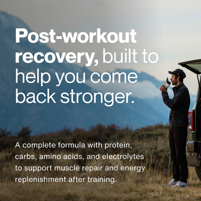 Athlete standing outdoors by a vehicle drinking a shake in a mountainous landscape. Overlaid text reads: “Post-workout recovery, built to help you come back stronger. A complete formula with protein, carbs, amino acids, and electrolytes to support muscle repair and energy replenishment after training.”