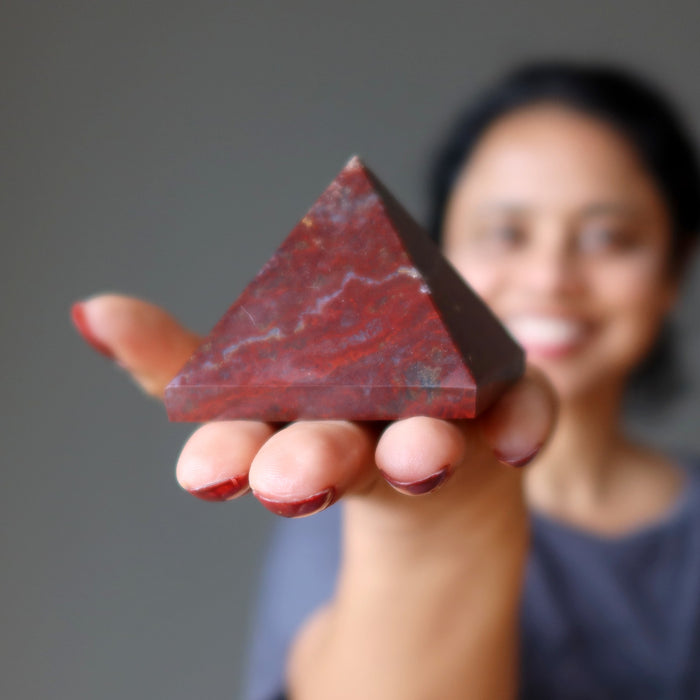 sheila of satin crystals holding out a red jasper pyramid