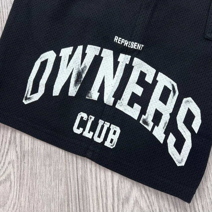 A close up view of the screen printed logo on the Represent Owners Club Mesh Shorts in Black.
