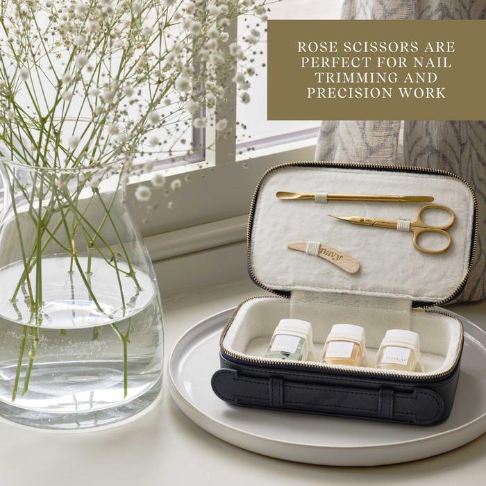 Set of rose scissors in a case on a table with a vase of flowers in the background