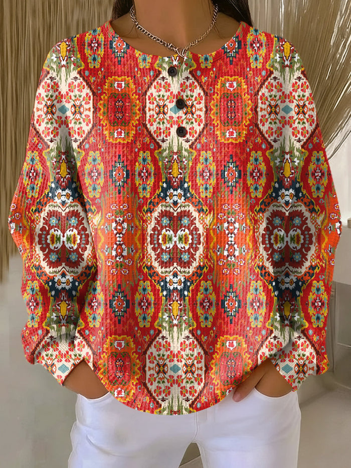 Orange waffle-knit women's sweater with ethnic floral pattern and relaxed fit