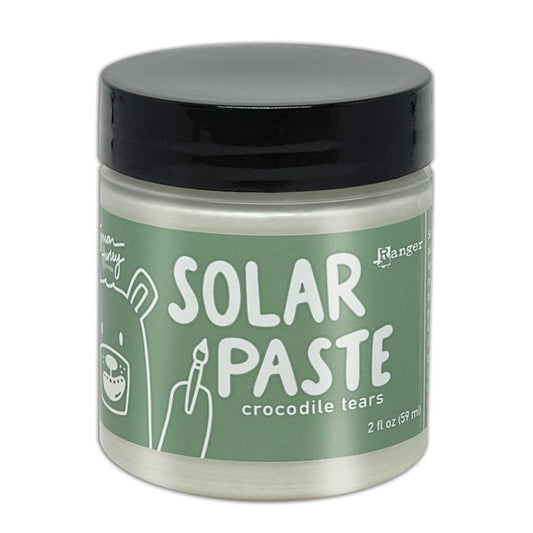 Simon Hurley  create. - Solar Paste - 2oz - Crocodile Tears. A creamy white paste with a metallic color shift when it hits the light. Color can be subtle on white cardstock but reveals an intense colored shine when applied to black. Available at Embellish Away located in Bowmanville Ontario Canada.