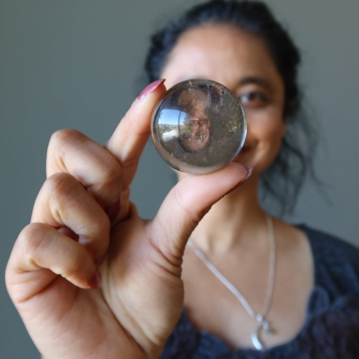 woman holding smoky quartz sphere