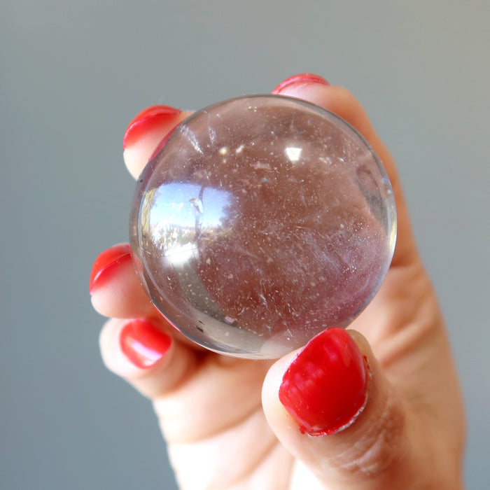 hand holding smoky quartz sphere