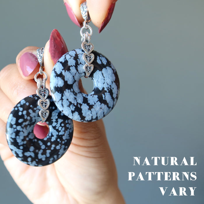 holding two Snowflake Obsidian Pendants